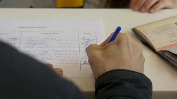 Mann unterschreibt ein Dokument oder schreibt Korrespondenz mit Nahsicht auf seine Hand mit dem Stift — Stockfoto