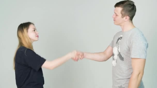 Hombre y chica estrechando las manos sobre fondo blanco. Retrato de primer plano de pareja, mujer hombre temblando aislado sobre fondo blanco. Emoción humana positiva sentimientos de expresión facial . — Vídeos de Stock