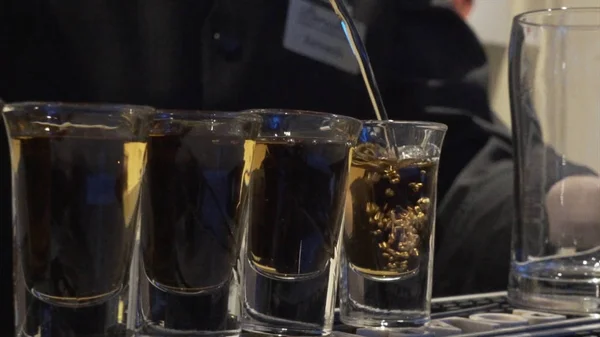 El camarero vierte mucho B52 o whisky. Cantinero vertiendo cóctel fresco en un vaso de lujo. Show de barman. El camarero sirve cócteles alcohólicos. El camarero está vertiendo tequila en vidrio. Soda. — Foto de Stock