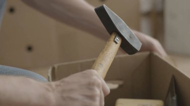 Adam kutudan bir çekiç çeker. Ev yenileme yapan erkek ve kutunun dışında bir çekiç çeker