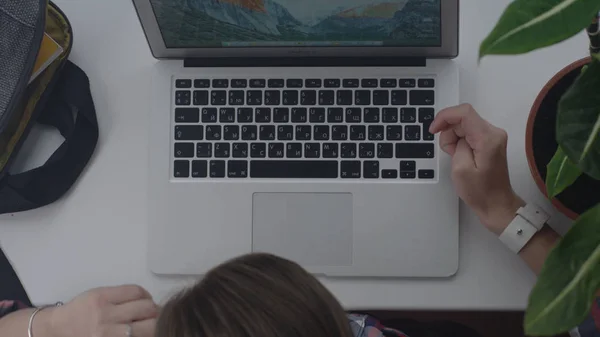 Закрытие рабочих рук на ноутбуке на панорамном окне. Женщина, работающая на ноутбуке на подоконнике — стоковое фото