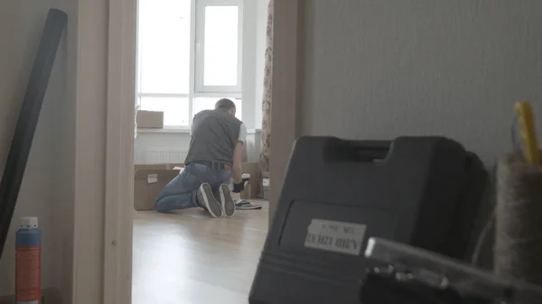 Mann sucht etwas in einer Schachtel, Gesamtübersicht — Stockfoto