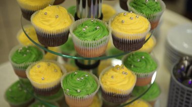 Cupcakes. Harika çikolatalı kek ve cupcakes. Karamelli çikolatalı kek ile fındık ve karamela şurubu. Yeşil ve sarı kek. Renkli kremler ile güzel cupcakes. Seçici odak. Bokeh
