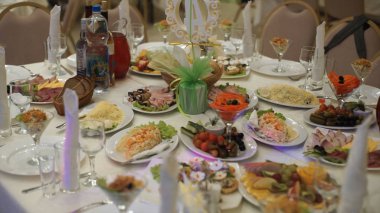 Yiyecek ve içecek ile tablo. Tablo catering hizmeti gümüş ve cam stemware ile partisinden önce restoranda ayarlayın. Spread-out aygıtları ve gıda içeren tablo. Noel ağacı