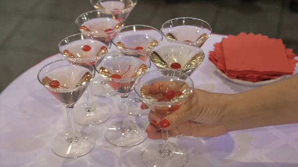 人々 は、テーブルからマティーニとウィスキーのガラスを取る。シャンパン グラス テーブルと党の背景に新鮮なチェリーで。結婚式でテーブルに別のアルコール飲料を含むガラスのトップ ビュー — ストック写真