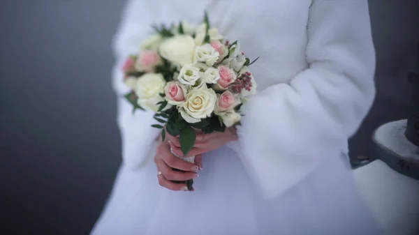 Невеста с цветами в руке на открытом воздухе. Невеста нервничает перед свадьбой. Невеста с духами. Прекрасный свадебный букет в руке невесты. Невеста держит красивый яркий свадебный букет. the — стоковое фото