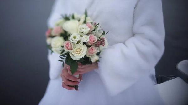 Noiva com flores na mão ao ar livre. A noiva está nervosa antes do casamento. Noiva a segurar um perfume. bouquet de casamento agradável na mão noivas. A noiva está segurando um lindo buquê de casamento brilhante. o — Fotografia de Stock