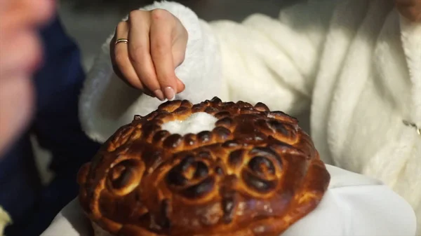 Chleb i sault na weselu. Pan młody kropi chleba z solą. Symbol szczęśliwy i dawno żonaty życia panny młodej i pana młodego. Rosyjski wediing tradycji. Pan młody i żona jeść chleb z sauld o — Zdjęcie stockowe