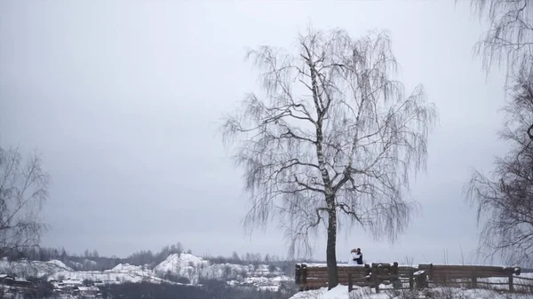 Giovani sposi che camminano fuori. Gli sposi camminano insieme nel parco in inverno o in estate e si tengono per mano. felice coppia nuziale passeggiando nel parco tra i cespugli ciliegia . — Foto Stock