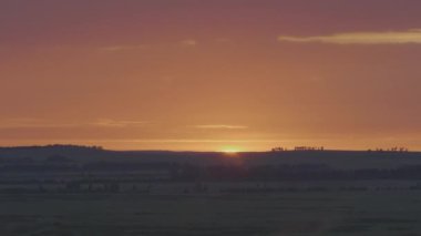 Alan veya çayır üzerinde doğal gündoğumu. Parlak dramatik gökyüzü ve karanlık yere. Kırsal manzara renkli gökyüzü gün batımında altında şafak Sunrise. Güneş bitti manzarası, ufuk. Sıcak renkler