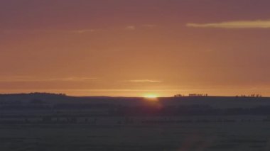 Alan veya çayır üzerinde doğal gündoğumu. Parlak dramatik gökyüzü ve karanlık yere. Kırsal manzara renkli gökyüzü gün batımında altında şafak Sunrise. Güneş bitti manzarası, ufuk. Sıcak renkler