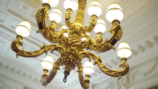Kroonluchter opknoping onder een plafond in een paleis. Luxe plafond kroonluchter — Stockvideo