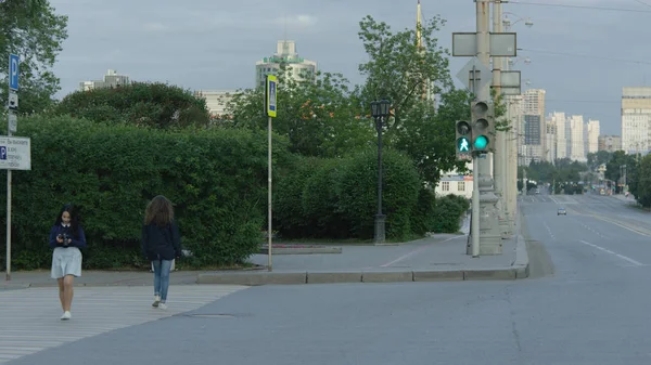 Giovane donna che attraversa una strada della città nella soleggiata giornata estiva — Foto Stock