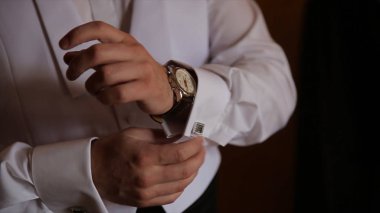 Damat kravat üzerinde takım elbise düğün elele geziyor. yakın bir el adamın giyer beyaz gömlek ve kol düğmesi nasıl. Siyah kravat beyaz forması sabitleme iş adamı. Damat Düğün günü sabitleme üzerinde kravat, vintage