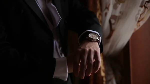 Pary młodej trzyma ręce na krawat, garnitur ślubny. zbliżenie dłoni człowieka jak nosi białą koszulę i spinki. Działalności człowieka mocowanie czarny krawat na białą koszulę. Krawat pana młodego na ślub dzień ustalenia, vintage — Zdjęcie stockowe