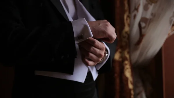 Bruidegom houdt handen op de stropdas, pak van het huwelijk. Close-up van een hand man hoe draagt shirt en cufflink witte. Zakenman verlijmen van zwarte stropdas op wit overhemd. Bruidegom inzake de vaststelling van de dag van de bruiloft binden, vintage — Stockfoto