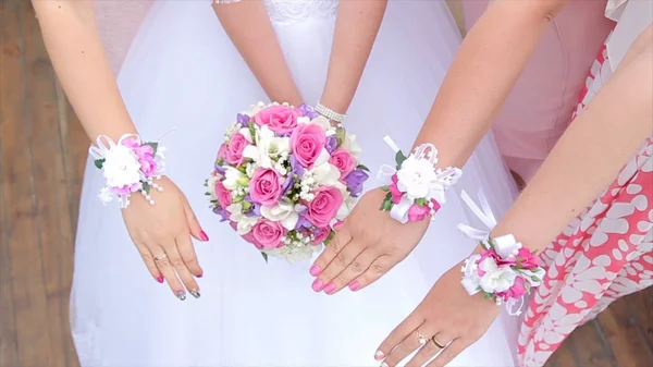 Gelin ve nedimeleri Çiçek demetleri göster. Gelin ve sevgili yan yana durmak ve buketleri ellerini göster. Gelinle el açık havada çiçekler. Gelin önce gergin 