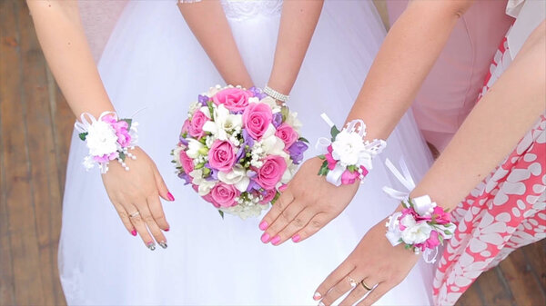 Подружки невесты и невесты показывают букеты цветов. Невеста и ее подруги стоят рядом и показывают букеты в своих руках. Невеста с цветами в руке на улице. Невеста нервничает перед
 