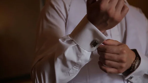 Bruidegom houdt handen op de stropdas, pak van het huwelijk. Close-up van een hand man hoe draagt shirt en cufflink witte. Zakenman verlijmen van zwarte stropdas op wit overhemd. Bruidegom inzake de vaststelling van de dag van de bruiloft binden, vintage — Stockfoto