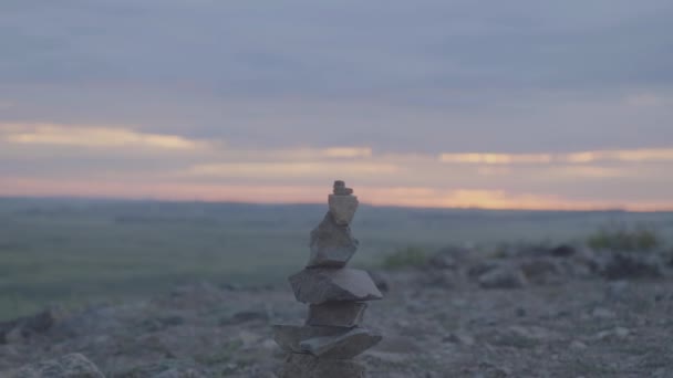 Каменная башня Дзен и баланс. Пачка гальки против неба. Каменная башня на фоне поля и утреннего неба — стоковое видео