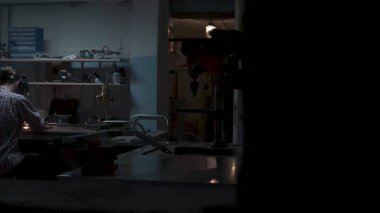 Kaynak metali Kaynak Makinası, taraf, en iyi görünüm için mavi kıvılcım sinek ile yakın çekim bir adamdır. Kaynak metal garajında adam