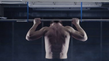 Plaka bar ile spor salonunda egzersiz güçlü adam. Yukarı, omuz ve kolları üzerinde egzersiz çeker. Arkadan Görünüm. Üzerinde kafa tutun. Yüksel egzersiz yapan kaslı erkek arkadan görünüm