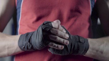 Adam yumruklarını Dövüşten önce esneme. Genç Tay boksör Close-Up kenevir halat fight veya eğitim önce sarılır eller