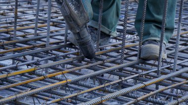 İnşaat işçisi. Beton dökme için takviye metal çerçeve yapma şantiye işçi