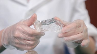 Doğal taş ametist veya başka bir maden, taş. Vahşi Ametist erkek beyaz eldiven eller. Taş elinde