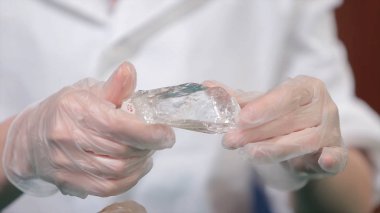 Doğal taş ametist veya başka bir maden, taş. Vahşi Ametist erkek beyaz eldiven eller. Taş elinde