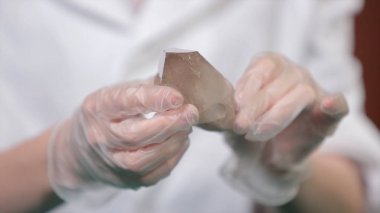 Doğal taş ametist veya başka bir maden, taş. Vahşi Ametist erkek beyaz eldiven eller. Taş elinde