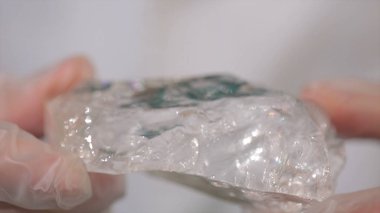 Bilim adamı holding elinde ham kristal örneği. Kaya kristali maden parçası tutan erkek el