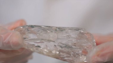 Bilim adamı holding elinde ham kristal örneği. Kaya kristali maden parçası tutan erkek el