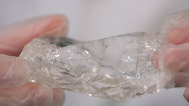 Bilim adamı holding elinde ham kristal örneği. Kaya kristali maden parçası tutan erkek el