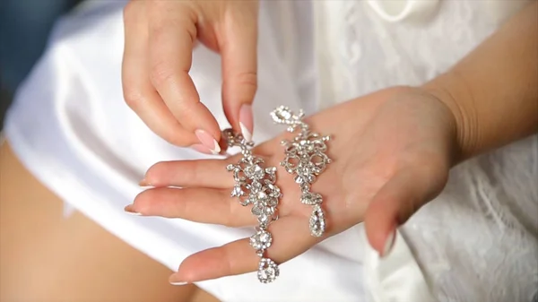 Pendientes de boda en una mano nupcial, novias por la mañana y accesorios de joyería y concepto de decoración. Pendientes de niña con perlas y diamantes de lujo — Foto de Stock