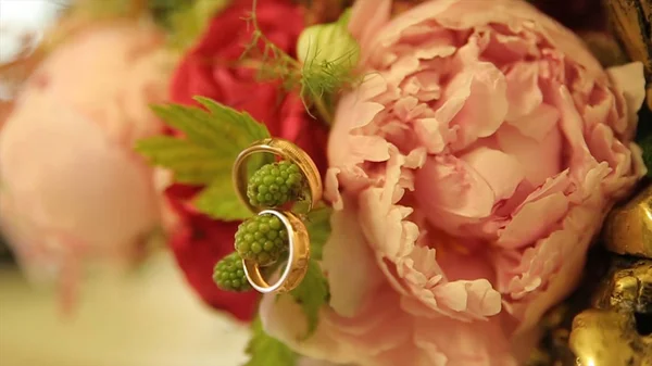 Vigselringar och rosa rosbukett. Vigselringar på en brudbukett. Vigselringar på en bukett rosor — Stockfoto