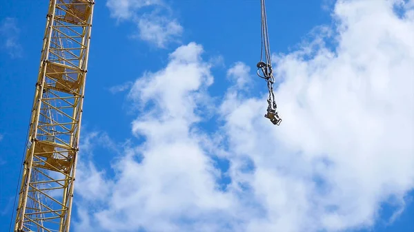 Ana binada ve açık mavi gökyüzü karşı jib ile sarı ve yeşil vinç patlamasının kapatın. Kule Vinçler gökyüzüne karşı bina