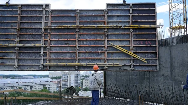 Construcción de un edificio moderno y un rascacielos. obrero de la construcción en obra — Foto de Stock