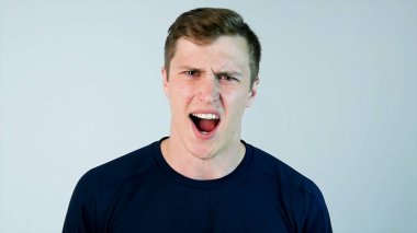 Fotoğraf makinesi ile siyah t-shirt ve gri arka plan adlı genç bir adam bağırıyor