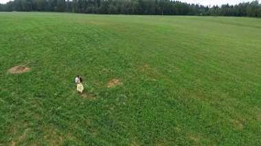Uçan nerede aşıklar yürümek yeşil alanın üzerinde. Kadın ve adam çalıştırdığı kenar boşluğu hava anketi. Alan. Sahada koşmak aşıkların hava anket