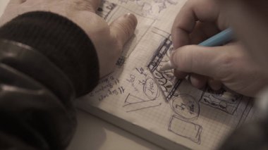 Adam bir defter çekiyor, notlar alıyor, kişi bir günlükte yazıyor, defter. Yazma