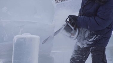 Heykeltıraş buz oyma görünümü. Hareket. Testere ile buz kes. Kes ve kar heykelini yap. Buzlu suyu balta ile kesiyorum. Buz heykel oyma. V-log