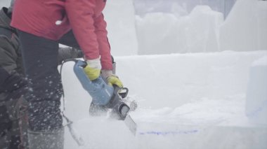 Heykeltıraş buz oyma görünümü. Hareket. Testere ile buz kes. Kes ve kar heykelini yap. Buzlu suyu balta ile kesiyorum. Buz heykel oyma. V-log