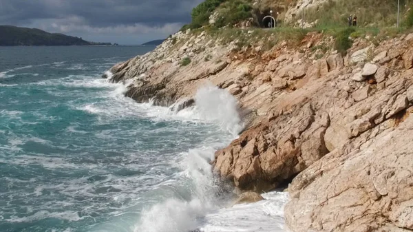 Vågorna bryta på en stenig strand, bildar en spray. Footage. Stänkande vågor på klipporna över havet — Stockfoto