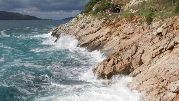 Vågorna bryta på en stenig strand, bildar en spray. Footage. Stänkande vågor på klipporna över havet — Stockfoto