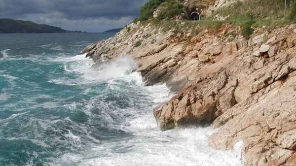 Vågorna bryta på en stenig strand, bildar en spray. Footage. Stänkande vågor på klipporna över havet — Stockfoto