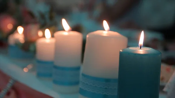 Tände ett ljus med en Match för att få en romantisk. Fantastiska ljusbehållare och ljusstakar är på bordet. Bo ljus med fridfull bakgrund av religiös ceremoni. — Stockfoto