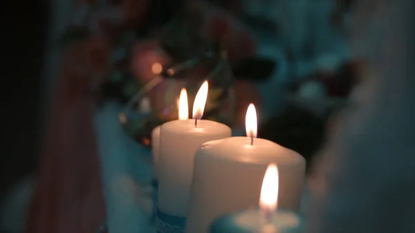 Iluminando uma vela com um fósforo para obter uma vela romântica. Anéis e castiçais incríveis estão sobre a mesa. Fique luzes com o fundo pacífico da cerimônia religiosa . — Fotografia de Stock