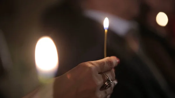 Зажигание свечи спичкой, чтобы получить романтическое свечение. Удивительные свечи и подсвечники на столе. Пребывание огни с мирным фоном религиозной церемонии . — стоковое фото