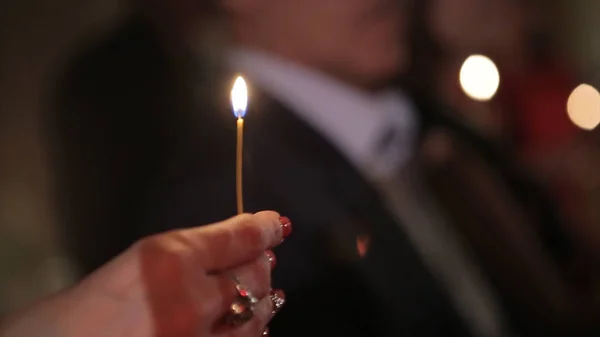 Lighting A Candle With A Match To Get A Romantic Candlelight. Amazing andles and candlesticks are on the table. Stay lights with the peaceful background of religious ceremony. — Stock Photo, Image